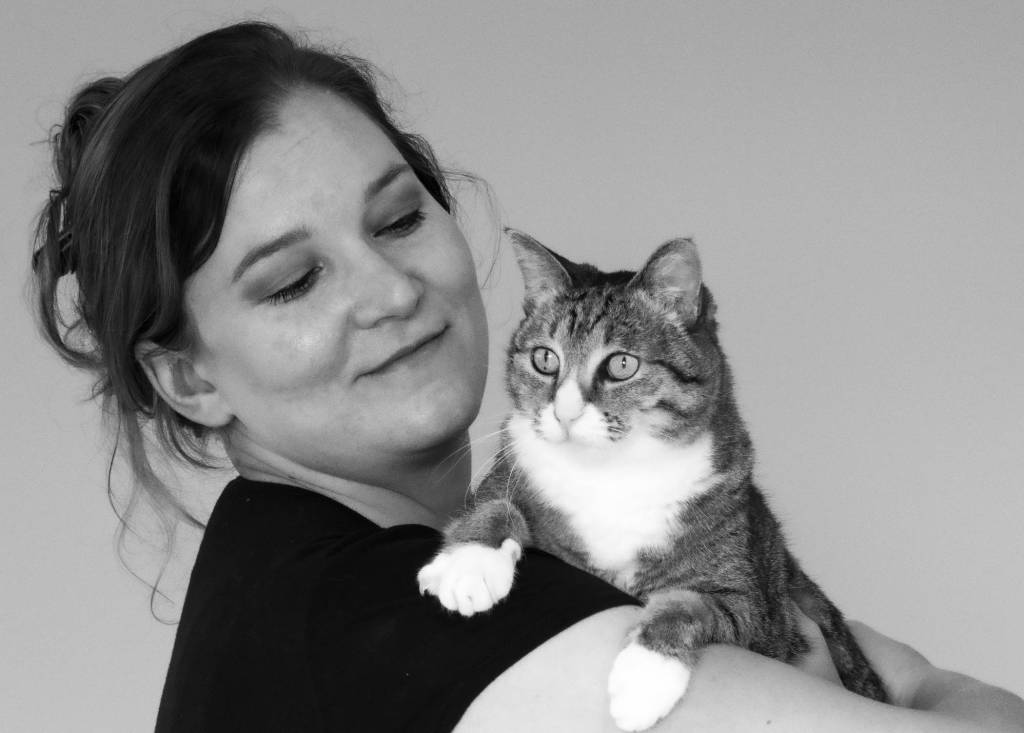 A photograph of Helen  Theron, the artist, holding her cat in her arms.
